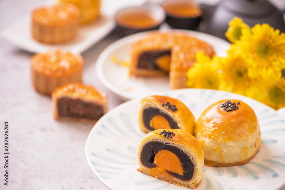 Mid-Autumn Festival traditional food concept - Beautiful cut moon cake on blue pattern plate on whit