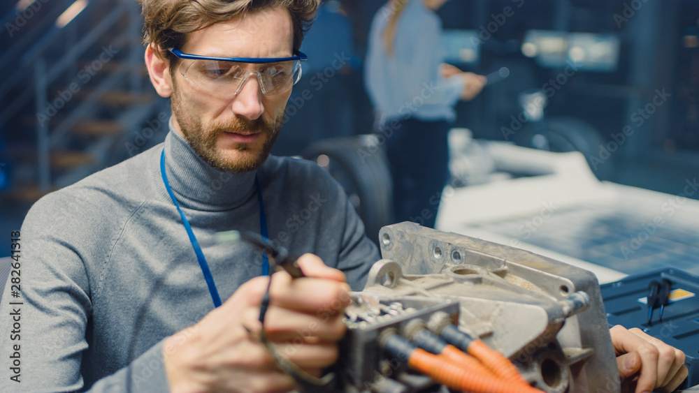 Professional Automotive Engineer in Glasses with a Computer and Inspection Tools is Testing an Used 