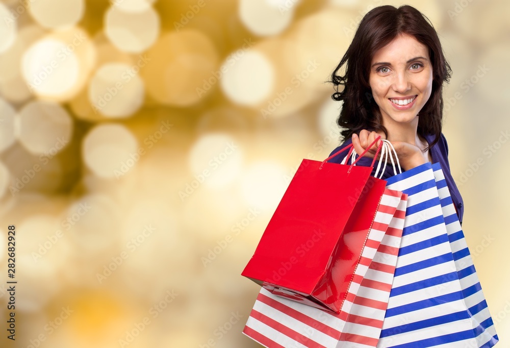 Young woman with shopping bags on blurred shopping mall background