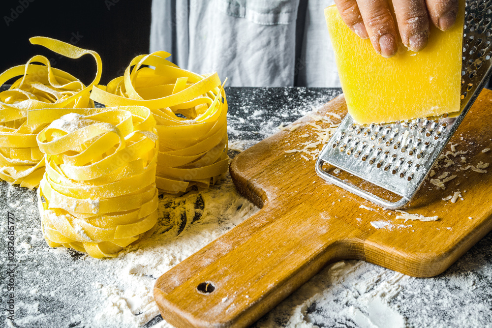 cooking pasta by chef in kitchen on dark background