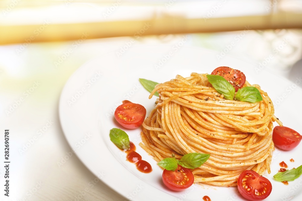 Spaghetti pasta with tomatoes and parsley on  table.