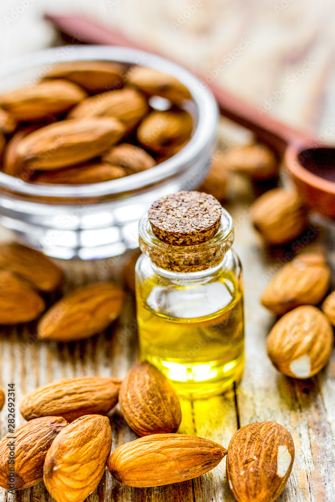 spa with almond oil in organic cosmetic set on wooden background