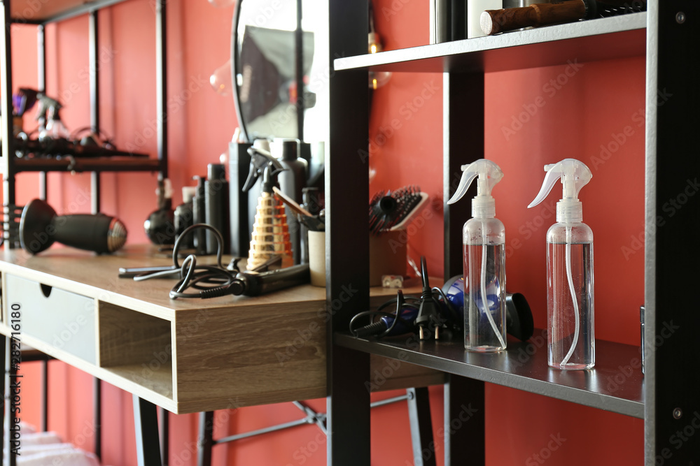 Hairdresser tools on shelves and table in beauty salon