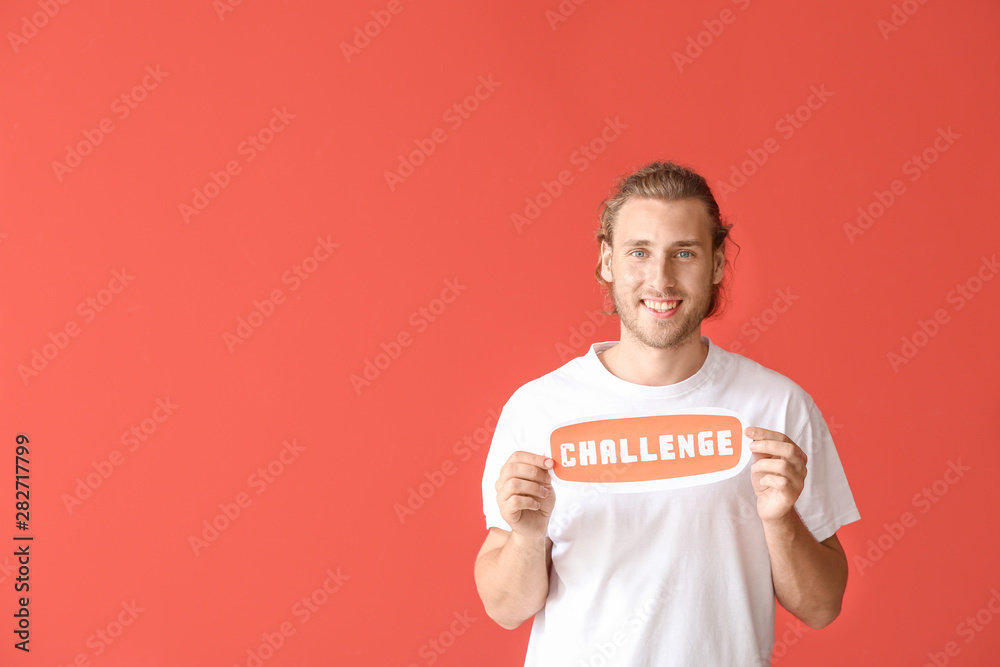 Male blogger holding paper with text CHALLENGE on color background