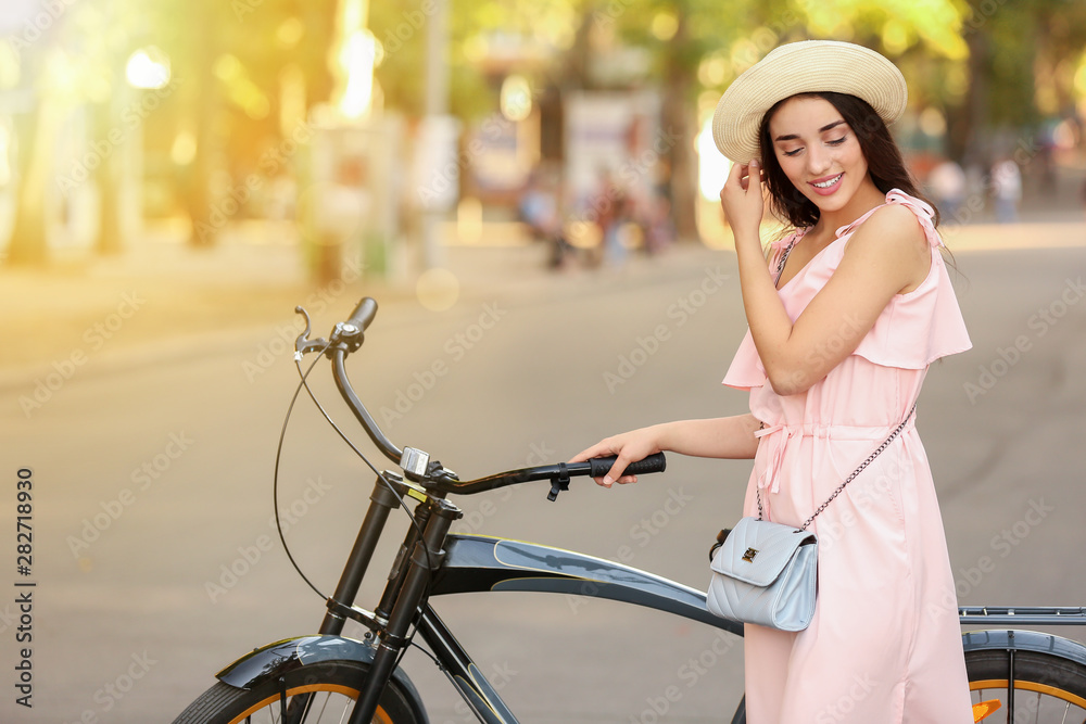 美丽的年轻女子在户外骑自行车