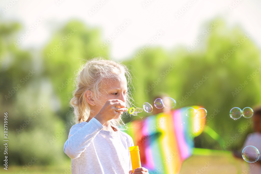 可爱的女孩在户外吹肥皂泡