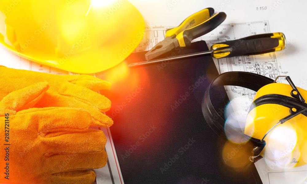 Yellow hard hat and blueprints in a construction concept