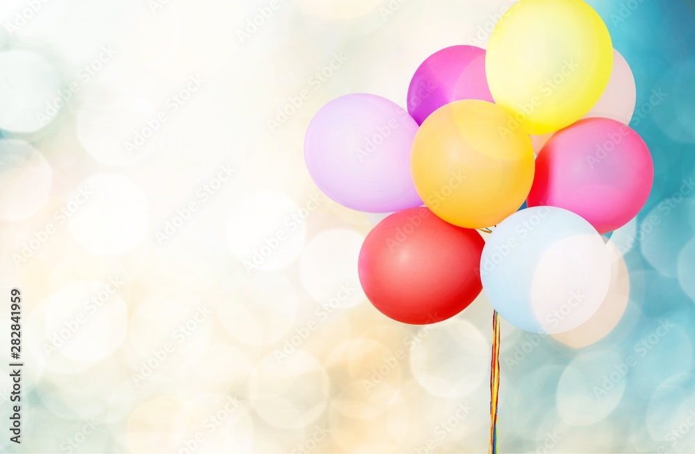 Colorful helium balloons on blue blurred background