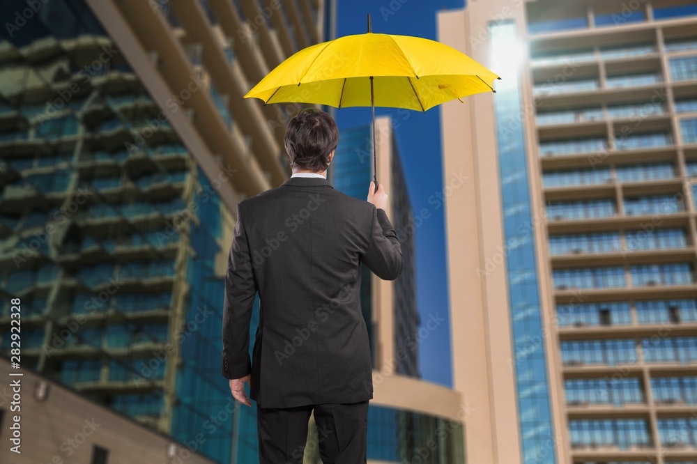 Portrait of  businessman with umbrella on background