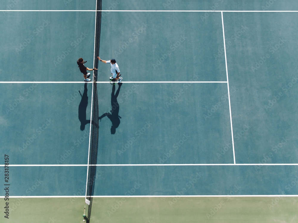 Tennis players shaking hands over the net