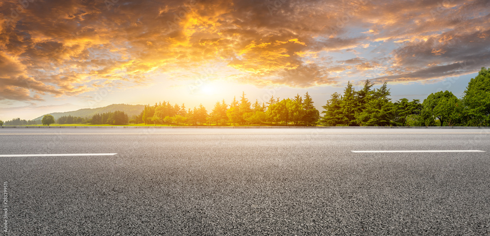 日落时的乡村道路和绿色森林自然景观