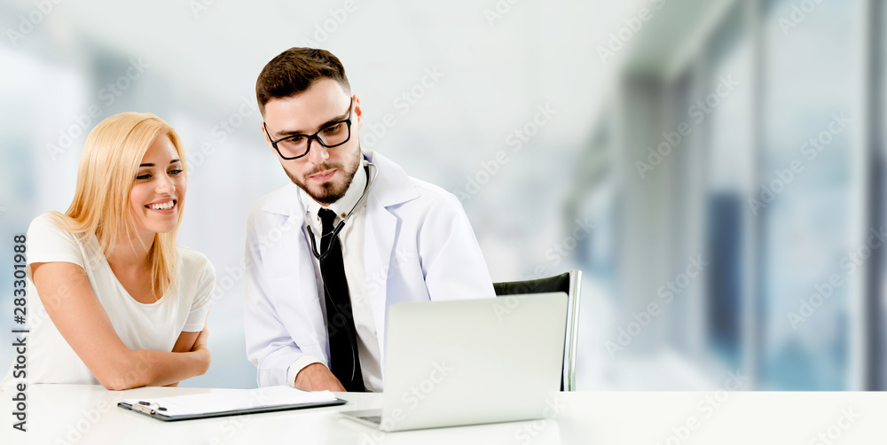 Doctor talking to patient in the hospital. The happy patient is listening to explanation from the do