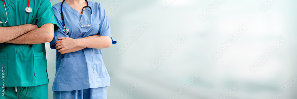 Two hospital staffs - surgeon, doctor or nurse standing with arms crossed in the hospital. Medical h