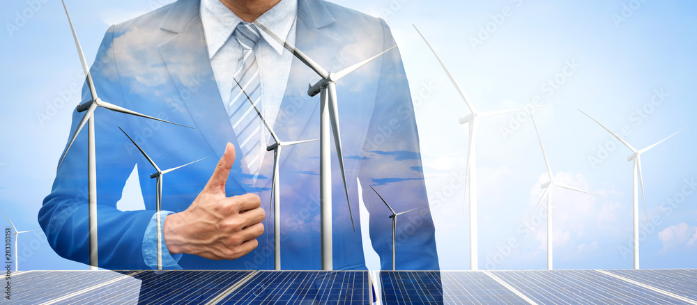 Double exposure graphic of business people working over wind turbine farm and green renewable energy