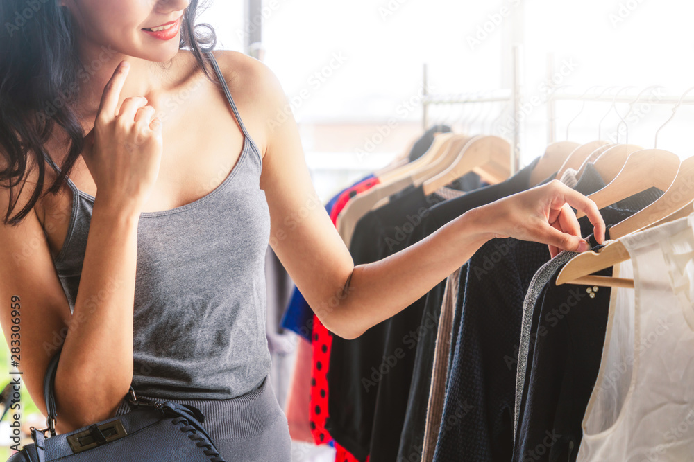 美丽的女人在购物中心的服装零售店买衣服。现代贸易生活