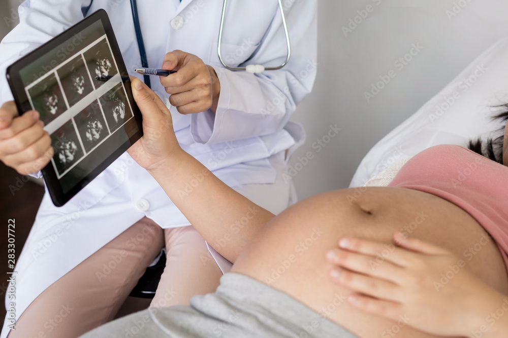 Happy pregnant woman visit gynecologist doctor at hospital or medical clinic for pregnancy consultan