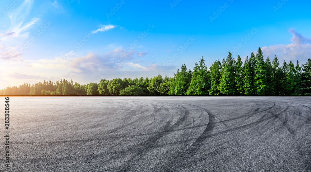 日落时的沥青赛道和绿树自然景观