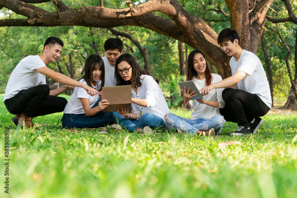 在大学或学校公园的小组项目中学习的年轻学生团队。快乐学习