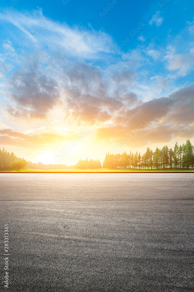 Asphalt race track and green woods nature landscape at sunset