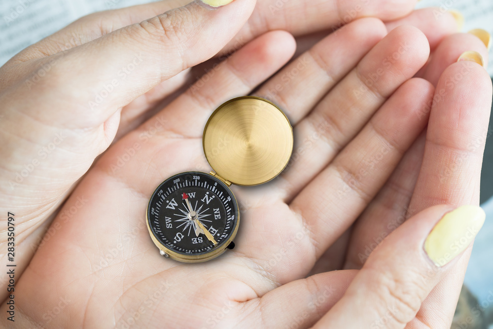 Compass in child’s hands supported by the family, parenting concept