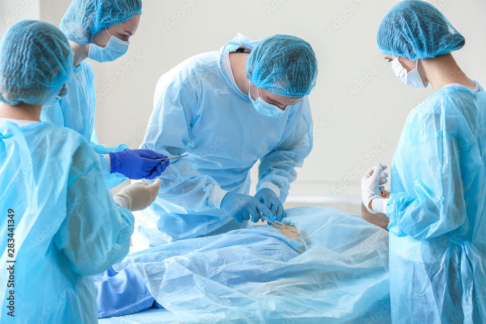 Plastic surgeons operating patient in clinic