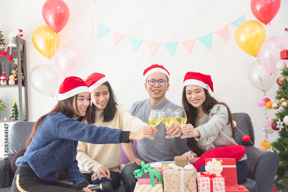 三个漂亮的亚洲女孩和一个男人用葡萄酒庆祝圣诞节或新年前夜