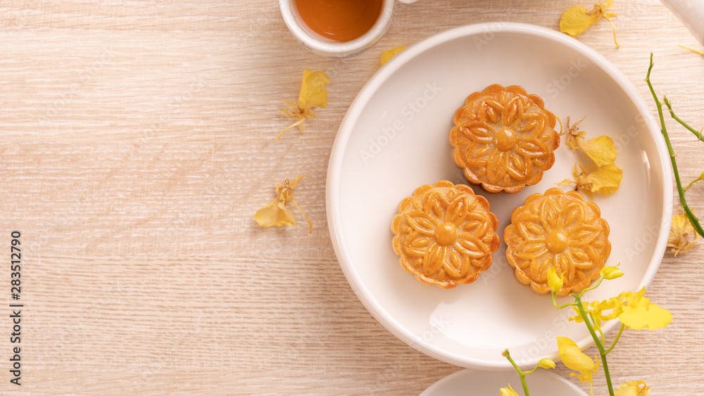 明亮木桌上的中秋美味月饼，12月的节日下午茶概念