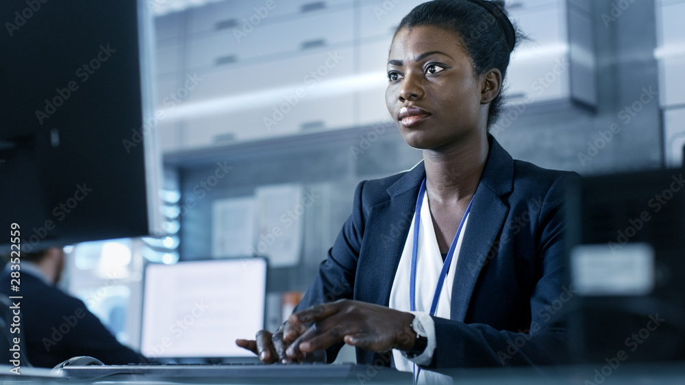 African-American Female Scientist Working on a Computer with Her Colleagues at Research Center.