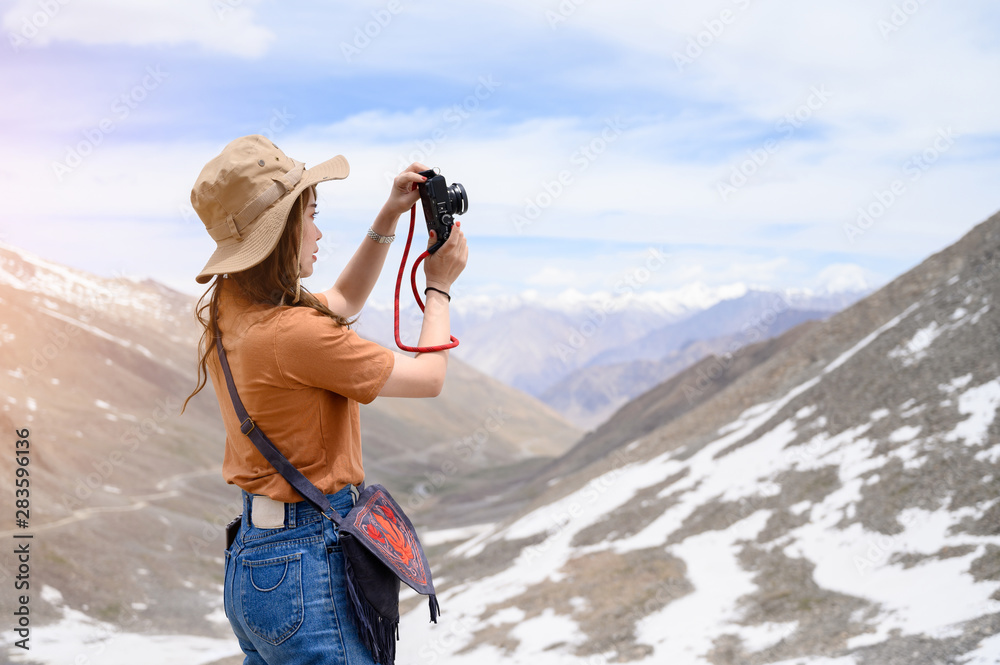 年轻亚洲女性在雪山、户外和旅行者概念上谈论照片的肖像