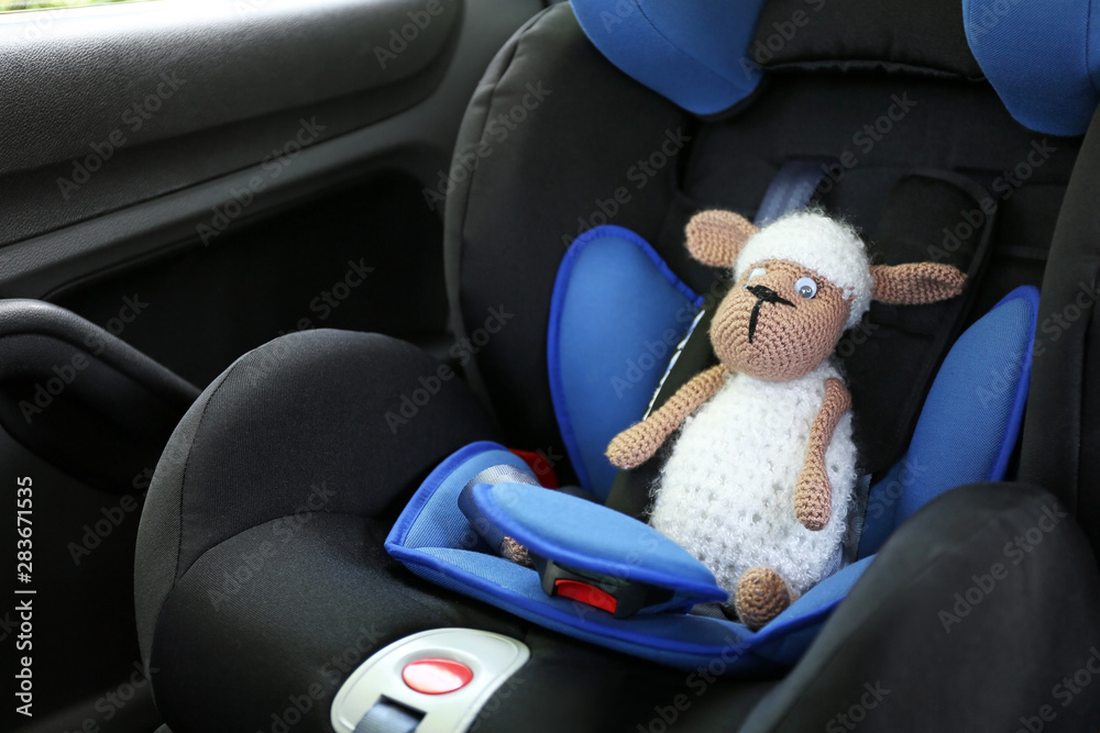 Toy sheep on car safety seat