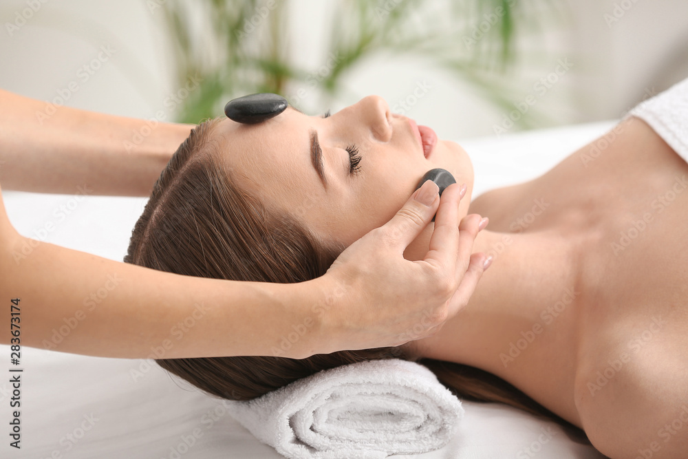 Young woman having facial massage in beauty salon