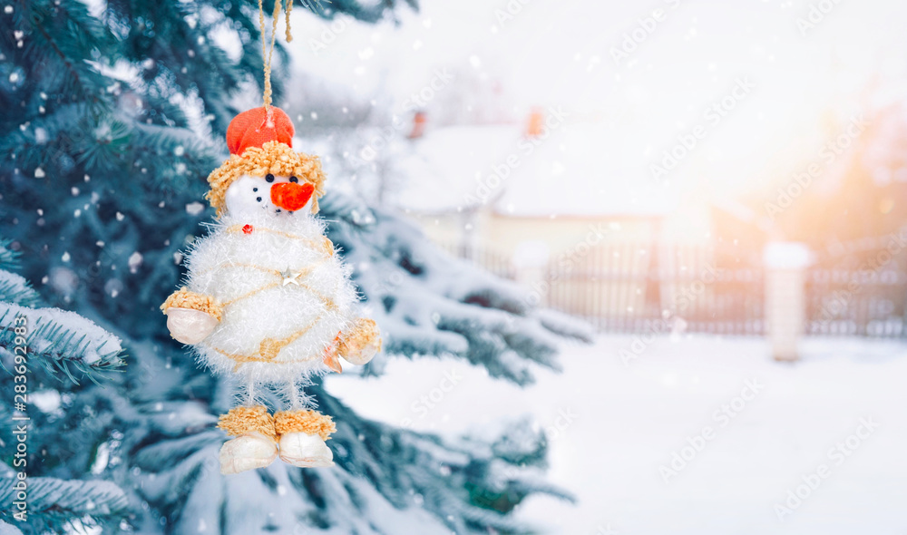 雪人在白雪覆盖的圣诞树上，户外有复制空间。