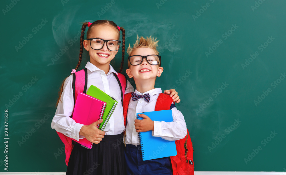 funny group children   schoolboy  and schoolgirl, student boy  and girl about school blackboard.