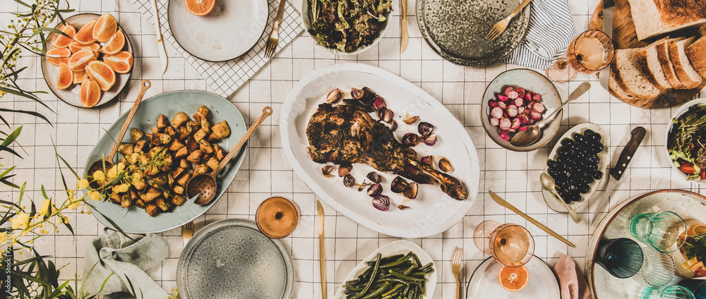 Family, friends gathering dinner. Flat-lay of roasted lamb shoulder, salads, baked vegetables, snack