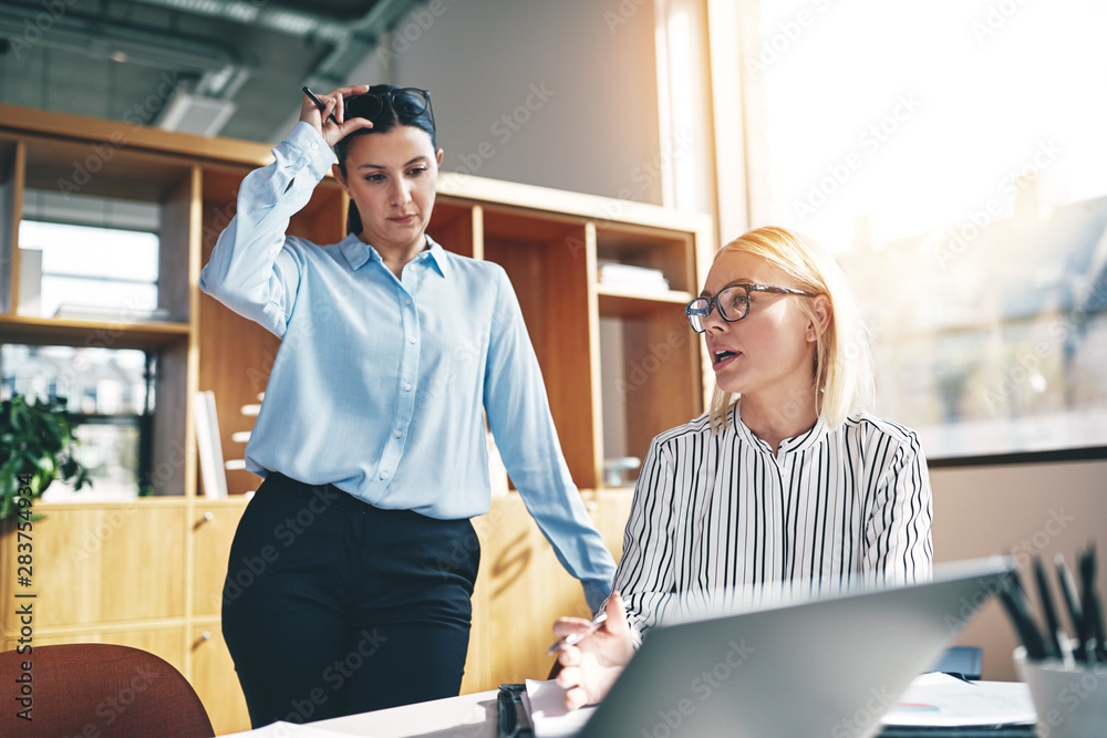 Young businesswoman and a colleague working at an office table