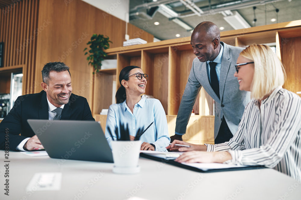 Group of diverse businesspeople laughing together during an offi