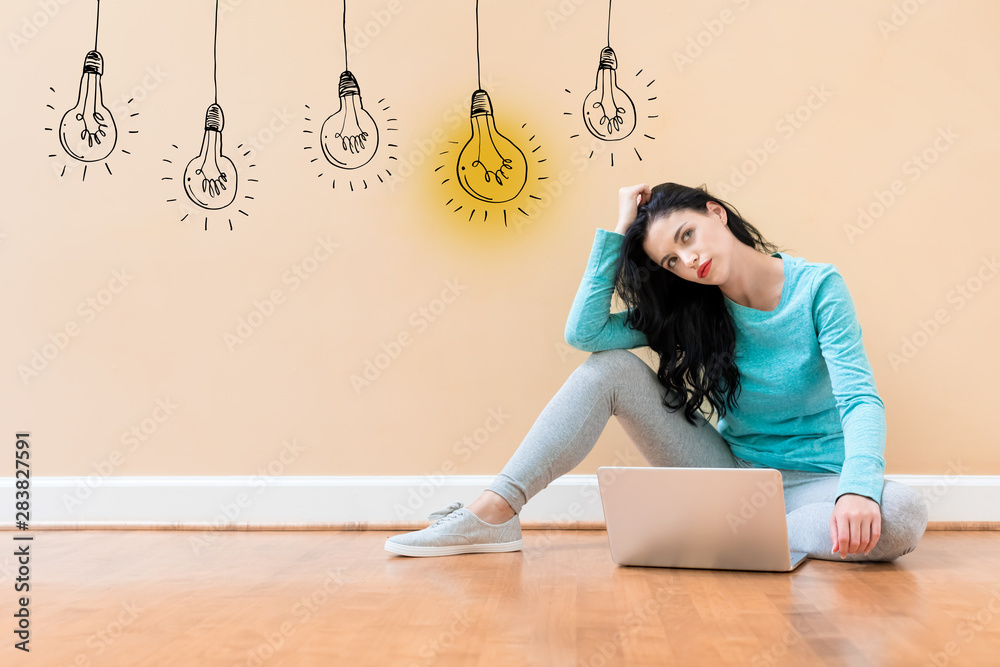 Idea light bulbs with young woman using a laptop computer