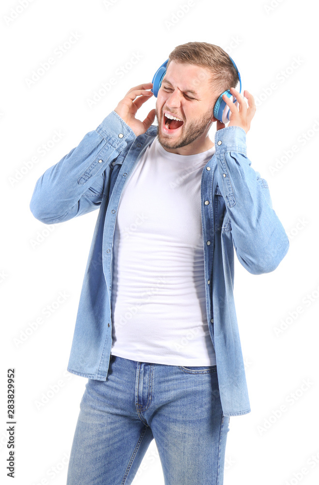 Handsome young man listening to music on white background