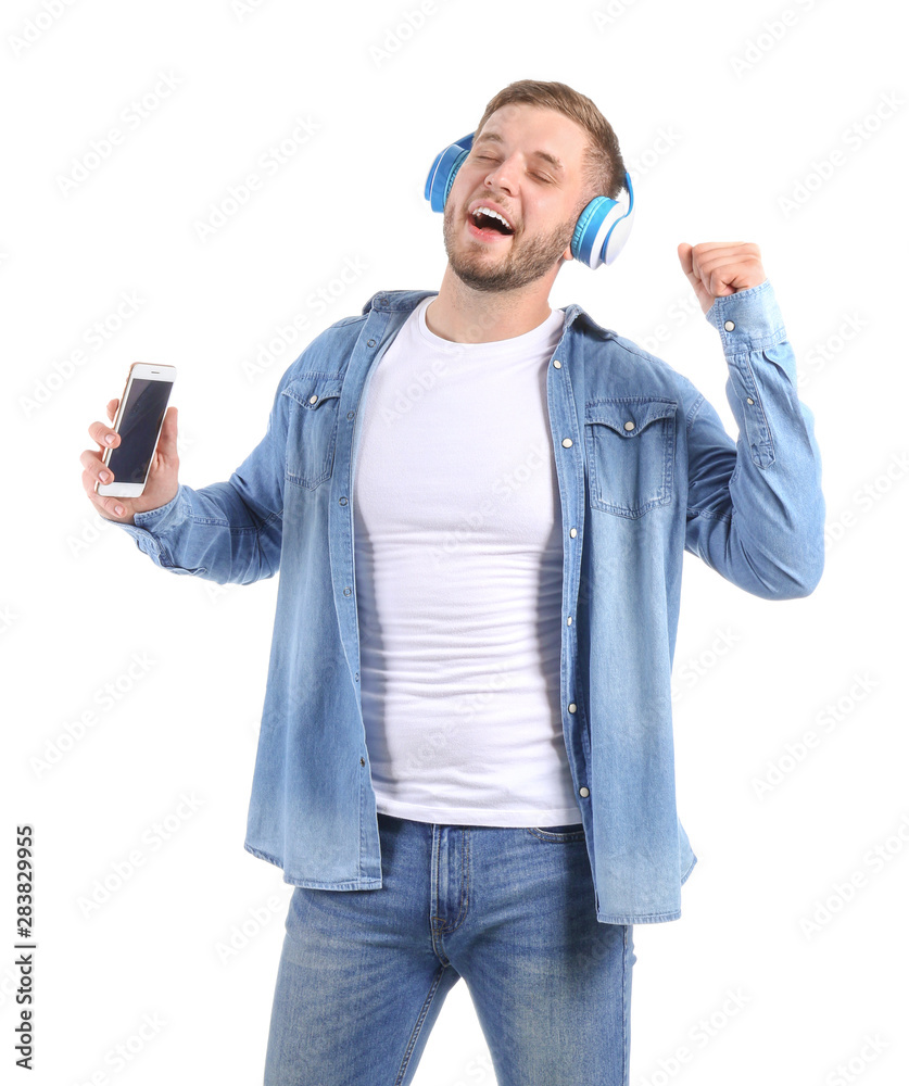 Handsome young man listening to music on white background