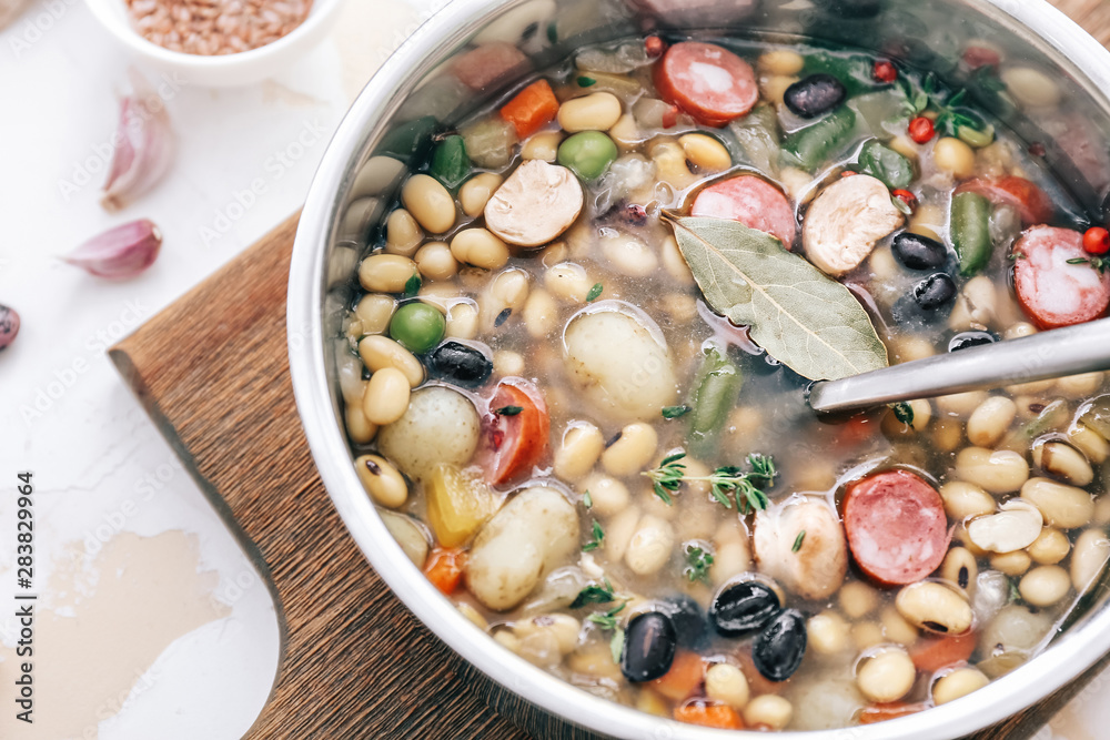 Tasty soup with legumes in saucepan on table