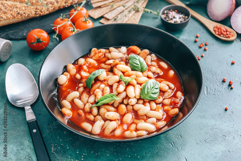 Tasty beans with tomato sauce in bowl on table