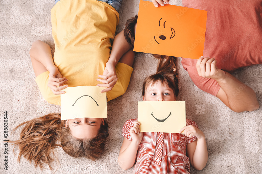 Family with emoticons lying on carpet