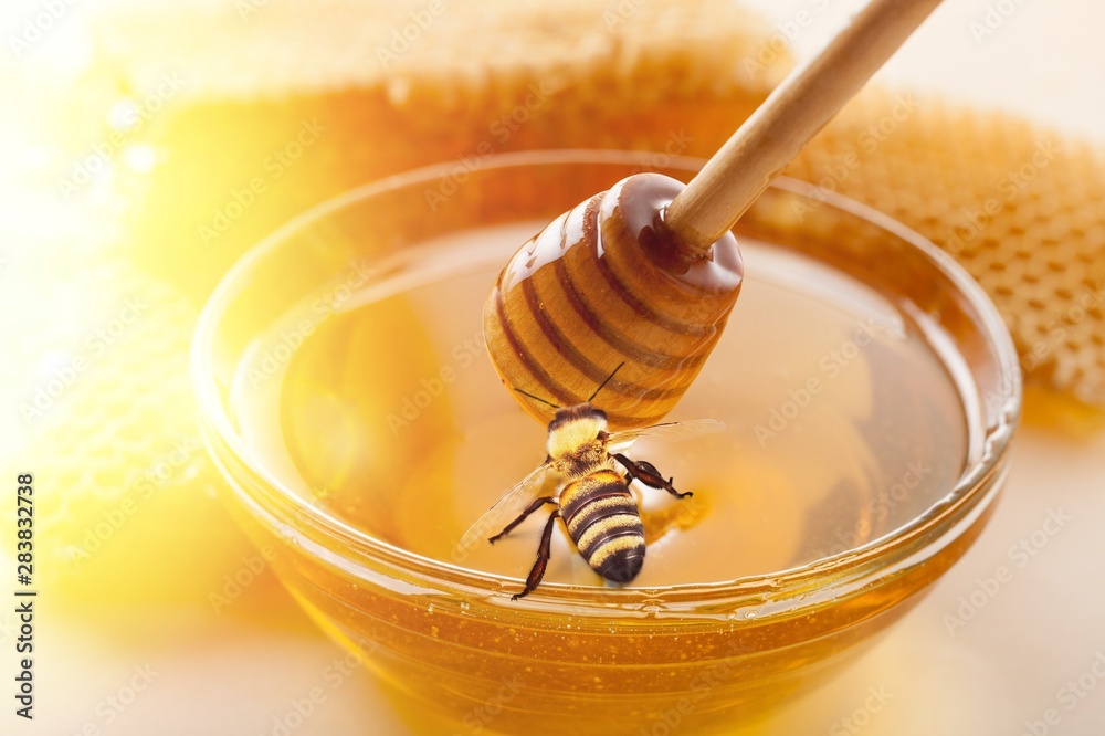 Honey and  wooden spoon  on background