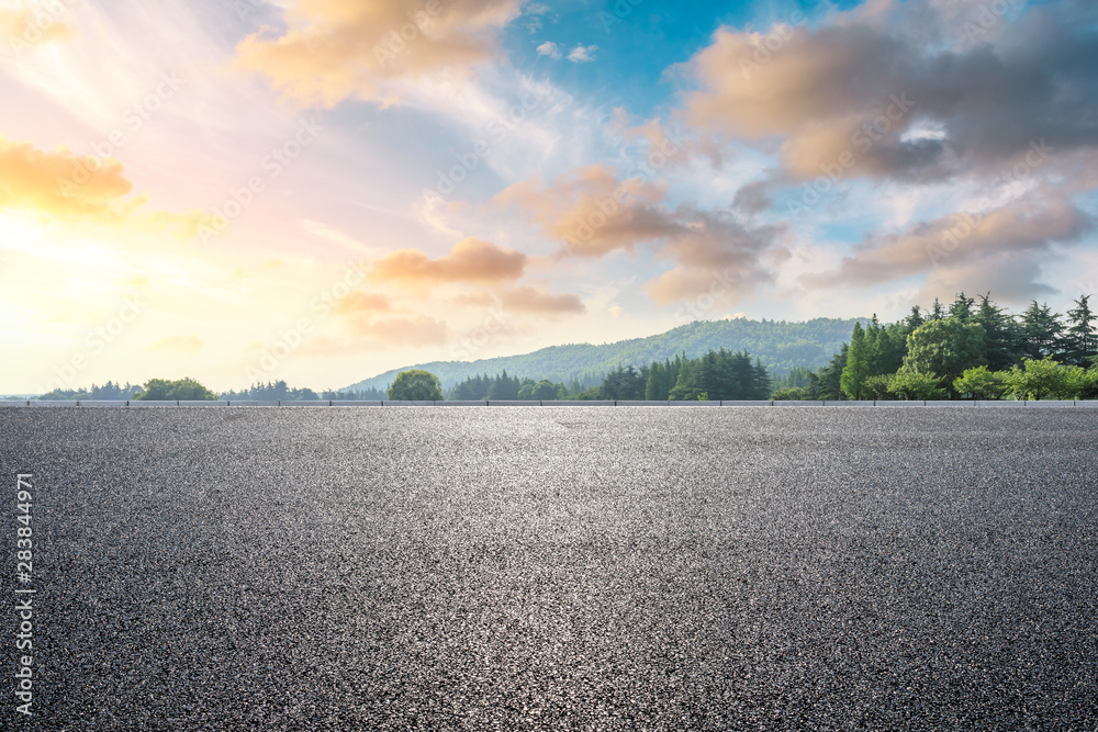 日落时的乡村道路和绿色森林自然景观