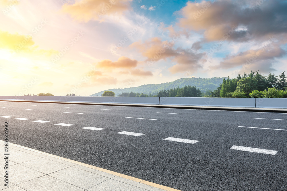 日落时的乡村道路和绿色森林自然景观