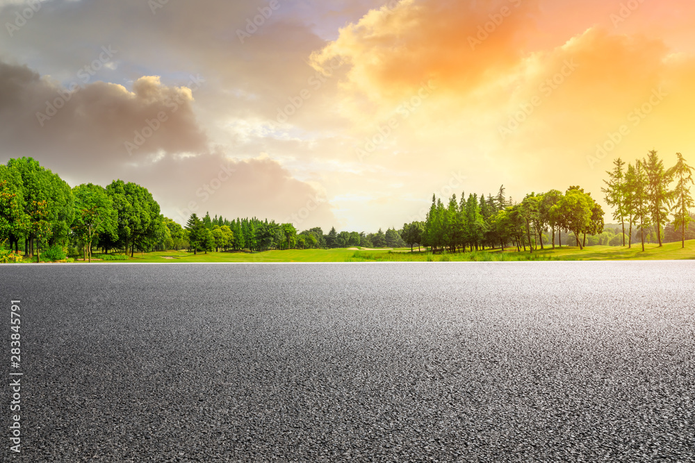 Country asphalt road and green woods nature landscape at sunset