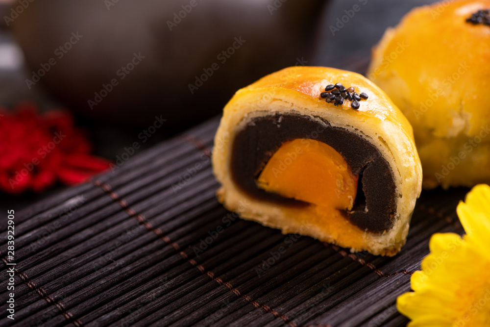 Tasty baked egg yolk pastry moon cake for Mid-Autumn Festival on black slate dark background. Chines