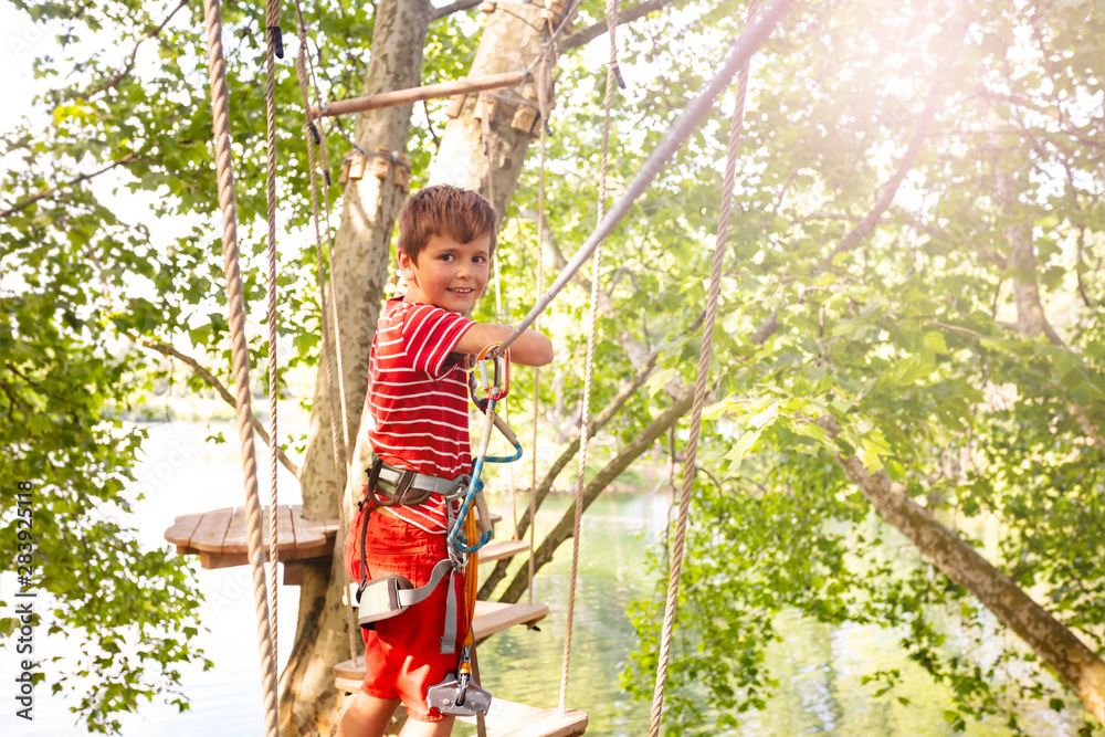 Happy boy portrait on the rope bridge between tree