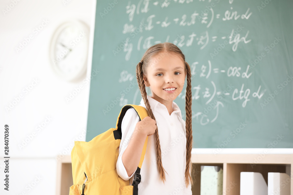 Cute little schoolgirl in classroom