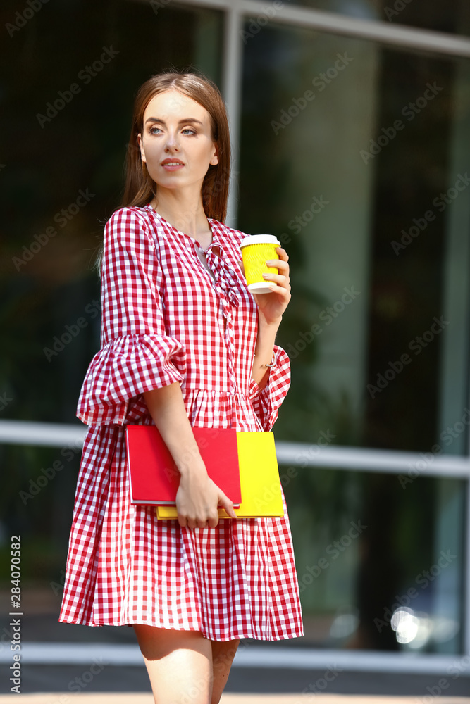 带着书和一杯咖啡的女学生在户外